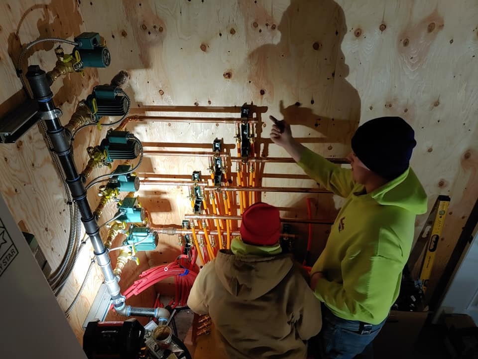 MPS crew members reviewing a complex boiler room pipe installation