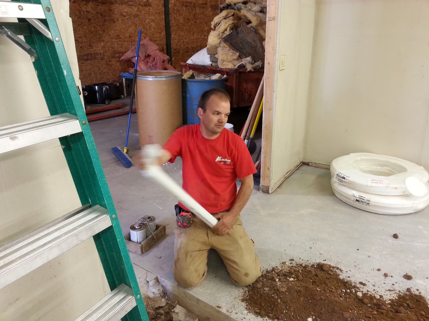 MPS plumber in red shirt working on pipe installation